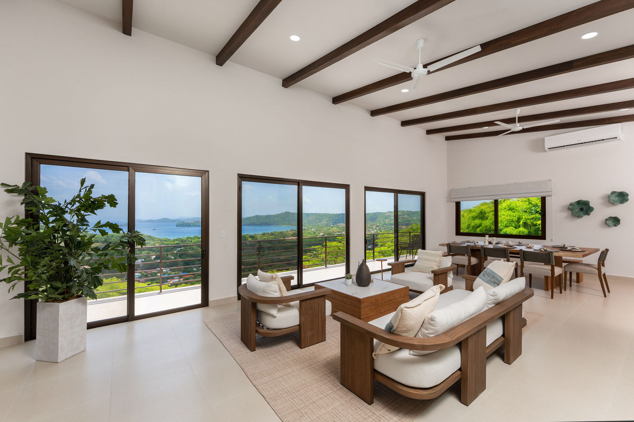 Living and dining area framed by ocean and mountain views