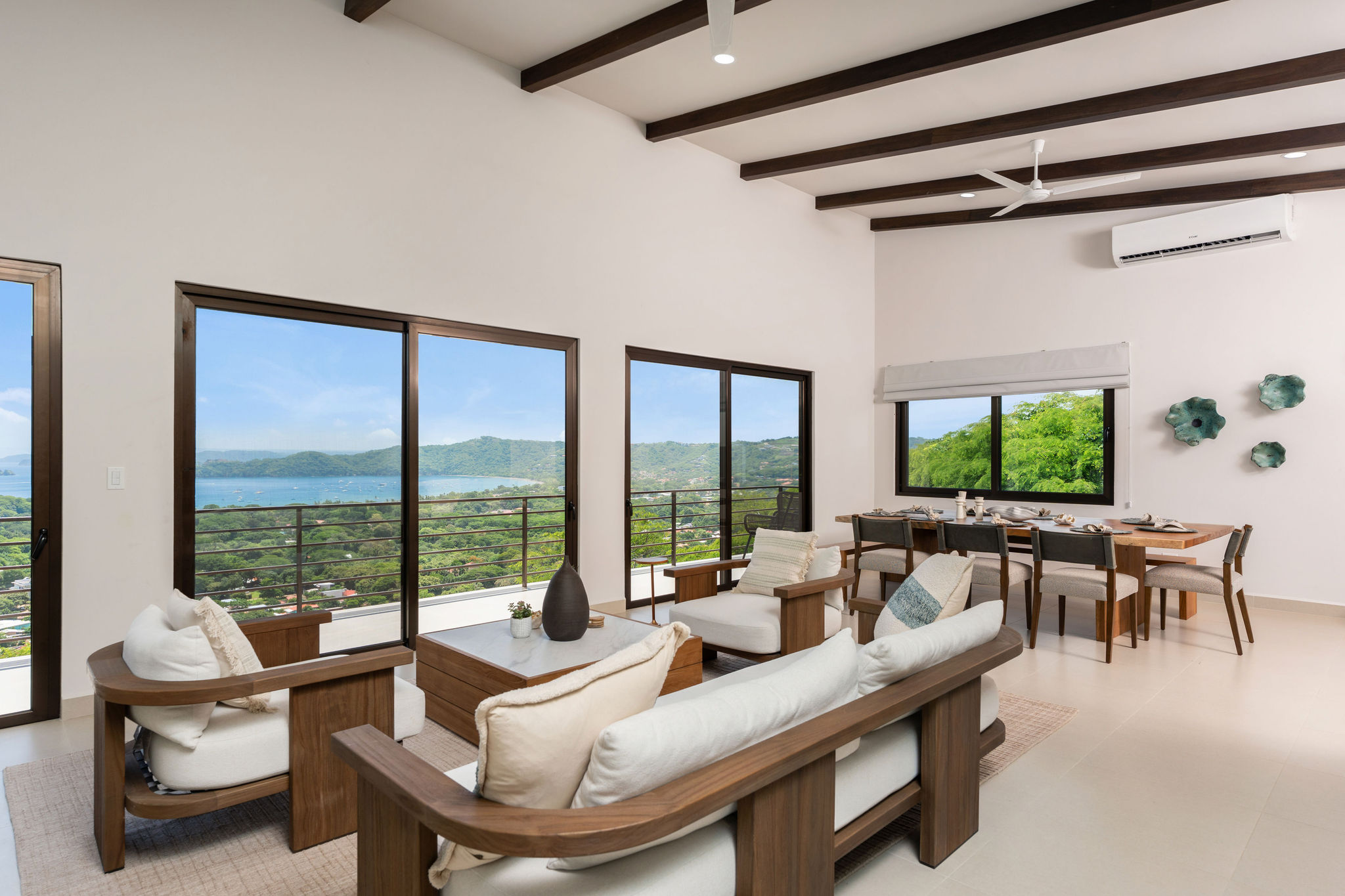 Living room and dining area with wide windows overlooking the hills
