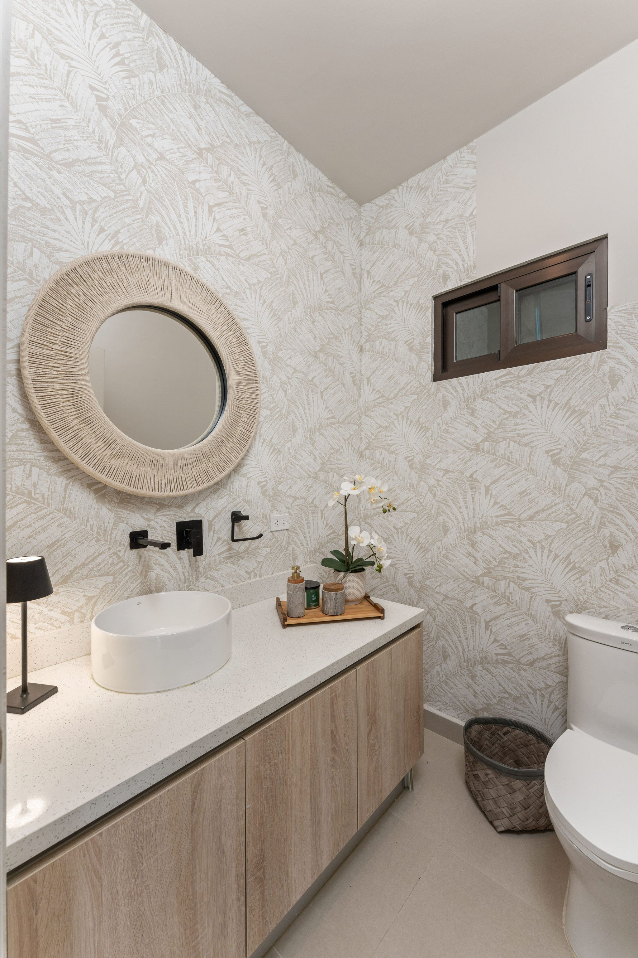 Guest bathroom with a vessel sink and tropical-patterned wallpaper