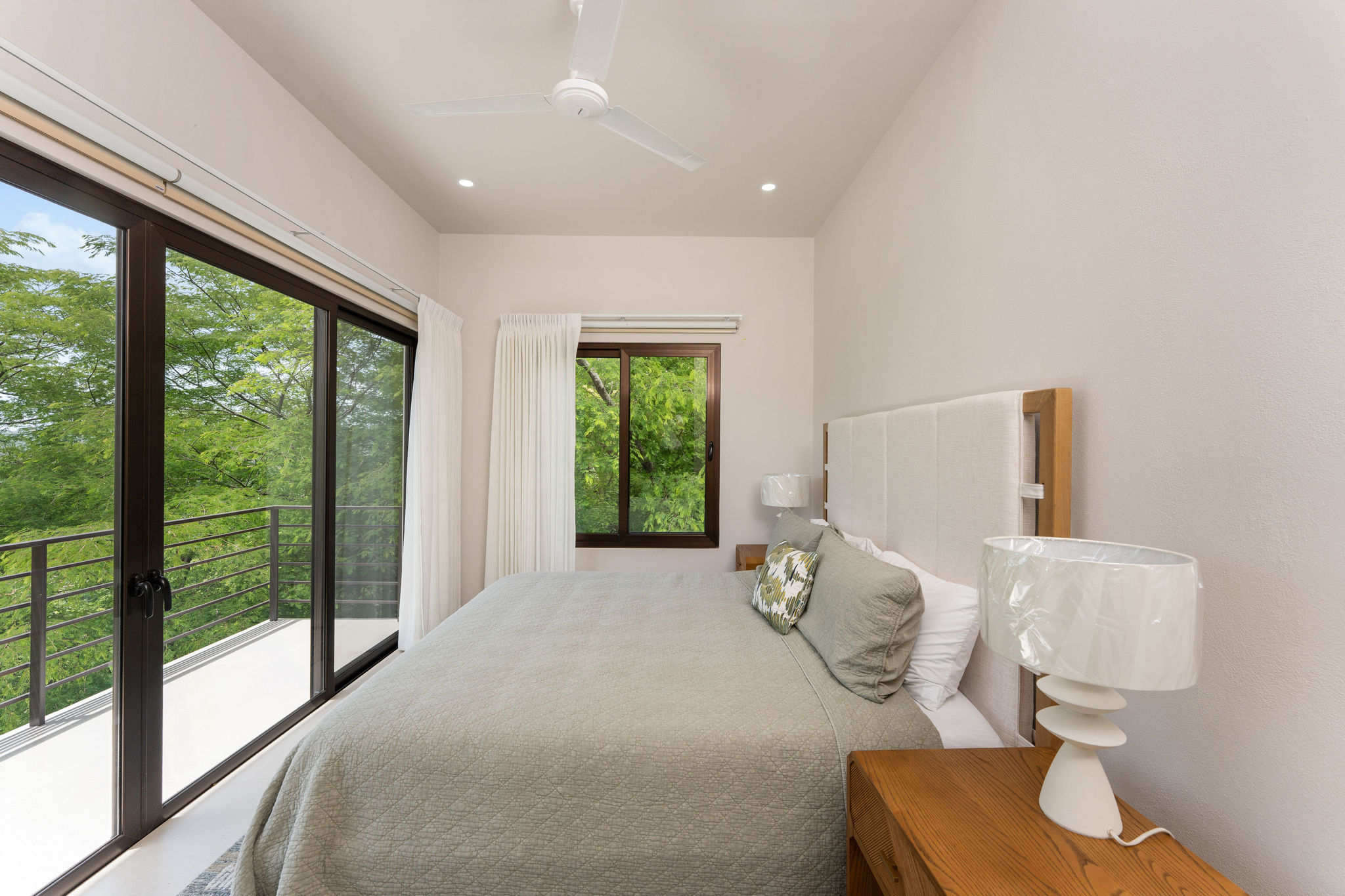 Bedroom with a bed, ceiling fan, and garden views