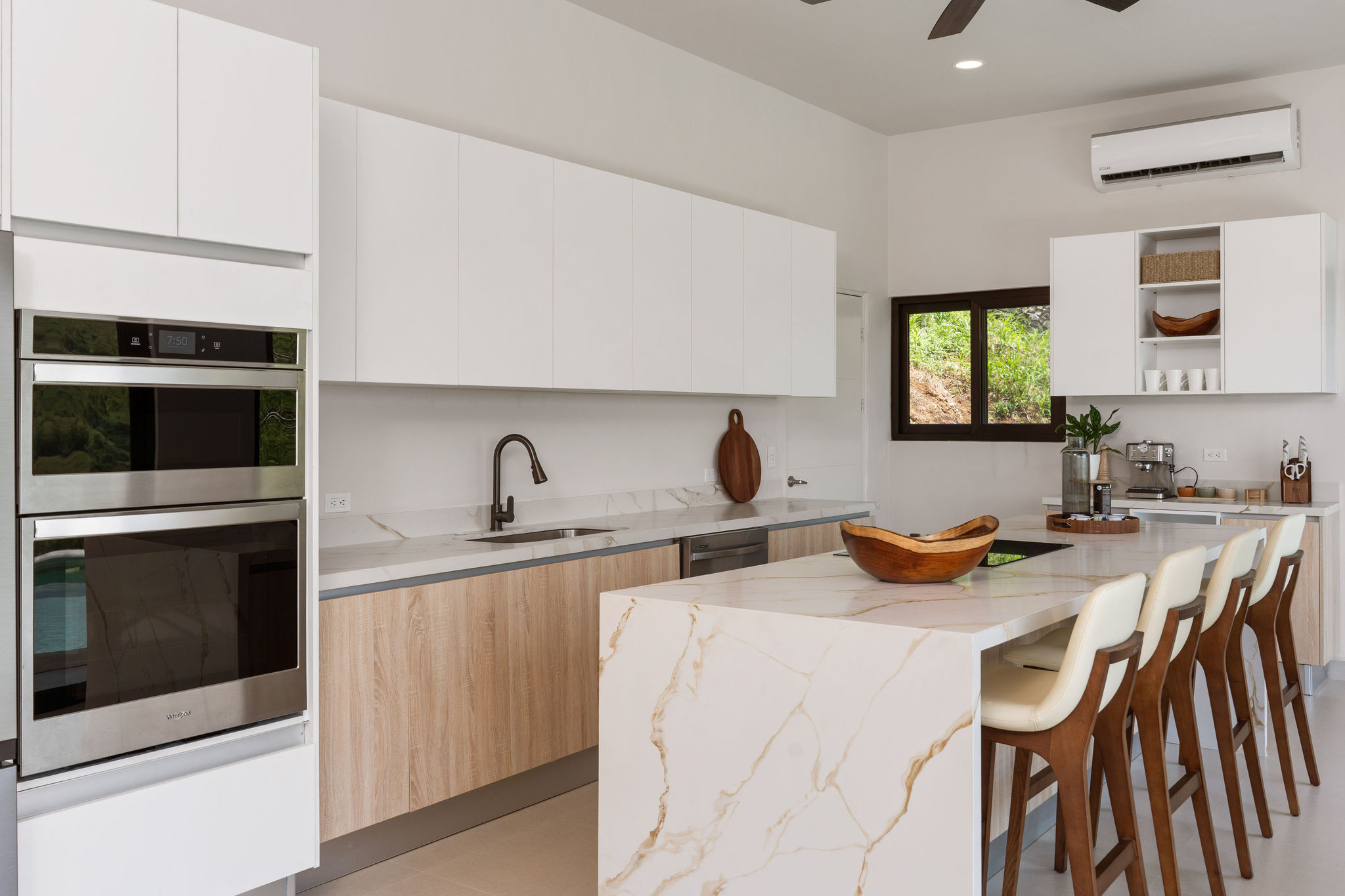 Kitchen cabinetry, double ovens, and island seating